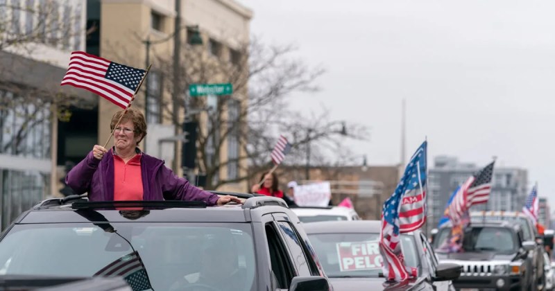 Women wave the American flag as vehicles circle the State Capitol Friday in Madison.