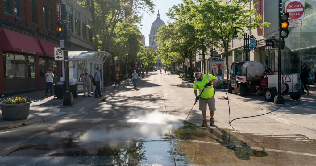 Peter Castro with the city of Madison parks department cleans up State Street after Saturday protests.