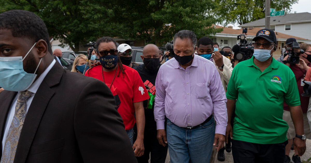 Rev. Jessie Jackson, center, walks with Justin Blake, red shirt, at the Justice for Jacob Community Celebration Sept. 1, 2020, in Kenosha, Wis.