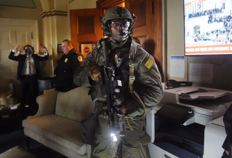 Congressional staffers hold their hands up while Capitol Police Swat teams check everyone in the room as they secure the United States Capitol. The supporters of President Donald Trump stormed a session of Congress on January 6, attempting to disrupt or halt efforts to certify Joe Biden's election win (Photo by OLIVIER DOULIERY/AFP via Getty Images)