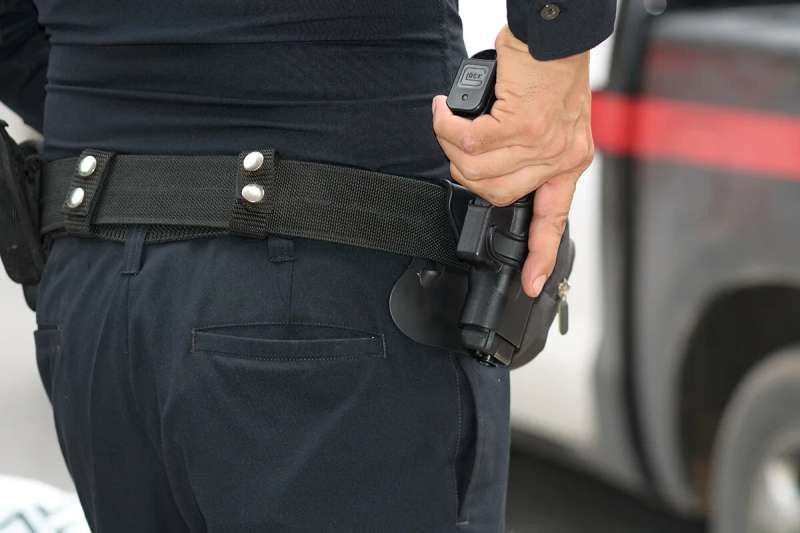 A police officer draws a gun
