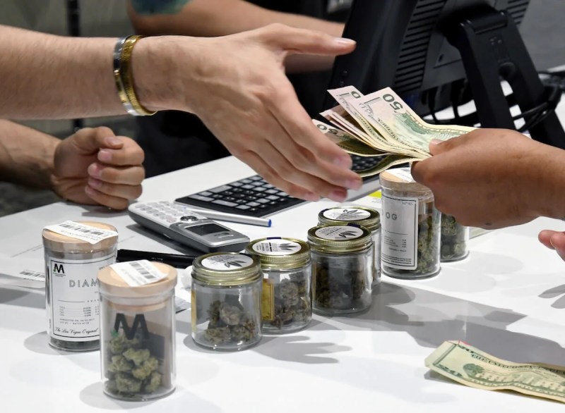 FILE - In this 2017 photo, a customer pays for cannabis products at Las Vegas dispensary. (Photo by Ethan Miller/Getty Images)