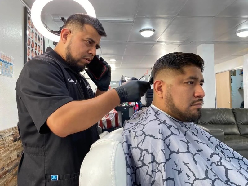 Emanuel Montalvo cuts Aaron Feria's hair on Oct. 12 at The Lounge Barbershop in Arcadia. The barbershop is one of a growing number of Latino-owned businesses in the Trempealeau County city that is home to a fast-growing Latino population. (Photo by Julian Emerson)