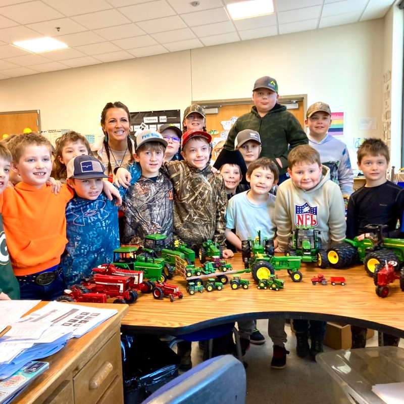 Teacher posing with students in class, Wisconsin.
