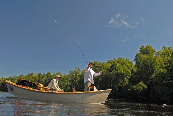 Todd Sether of the Twin Cities casts a fly on Wisconsin's Chippewa River, looking for smallmouth bass and muskies, while guide Larry Mann positions his drift boat.