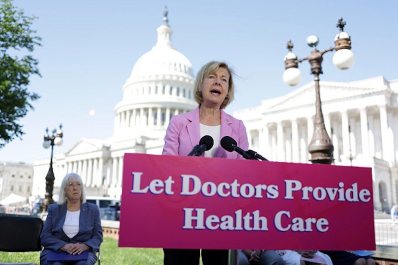 At a news conference on reproductive rights, Sen. Tammy Baldwin speaks in front of a "Let Doctors Provide Health Care" sign