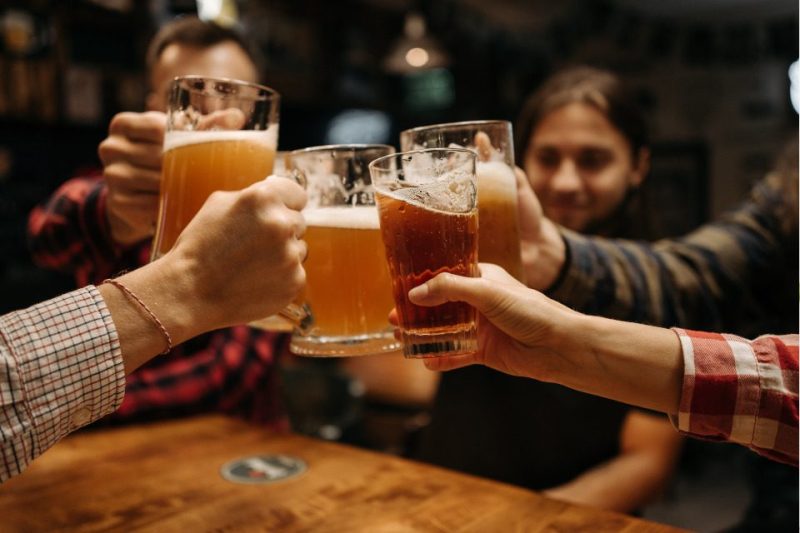 People clinking beer mugs together. Cheers!