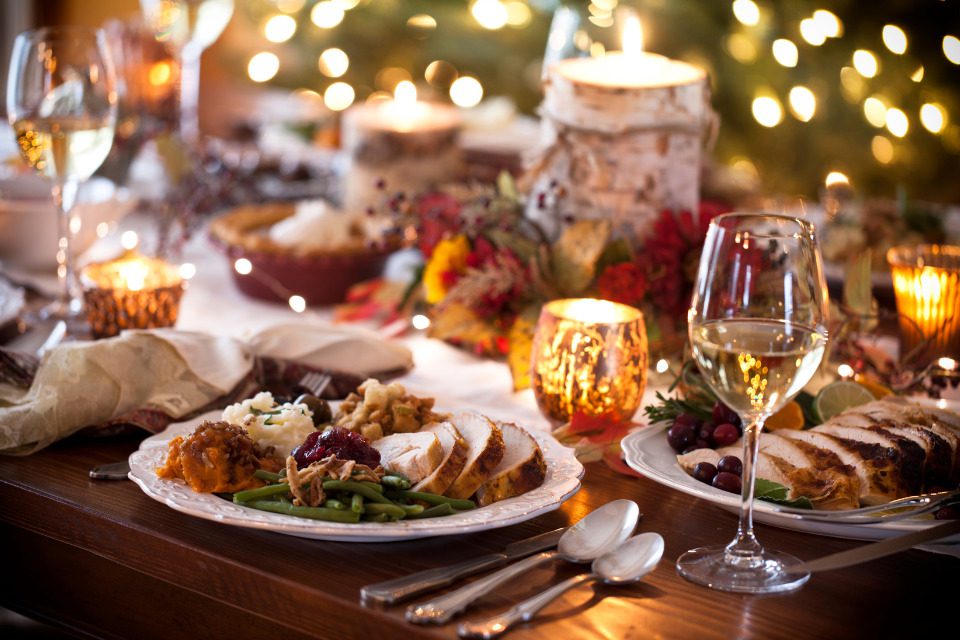 A beautifully set dining table with hearty meat and potatoes on a plate.