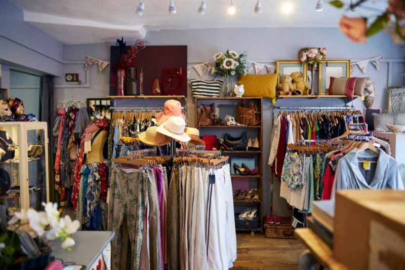 A thrift shop with clothes, hats, and accessories.