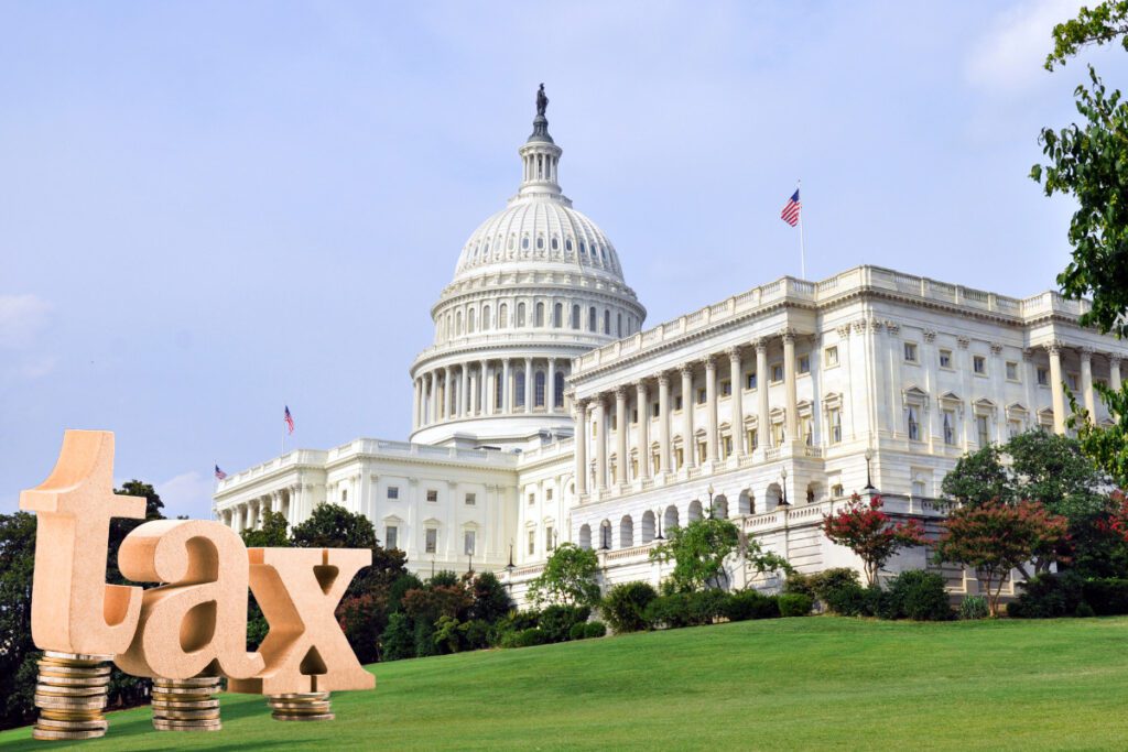 Fair Taxes. The word Tax stacked on coins. Capitol, Washington DC in background