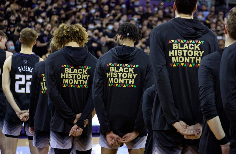 FILE - Washington players stand during the playing of the national anthem wearing warm-up jackets for Black History Month before an NCAA college basketball game against Arizona, Feb. 12, 2022, in Seattle.