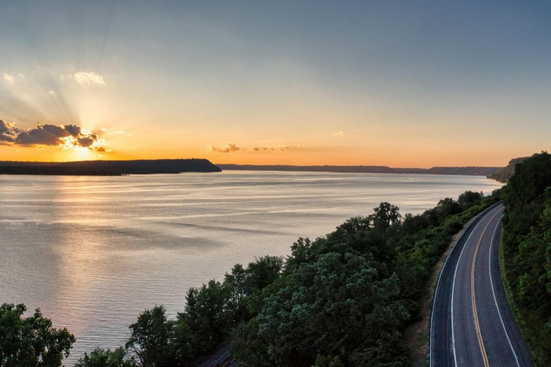 Environment - rural Wisconsin. A long road with a river and sun setting