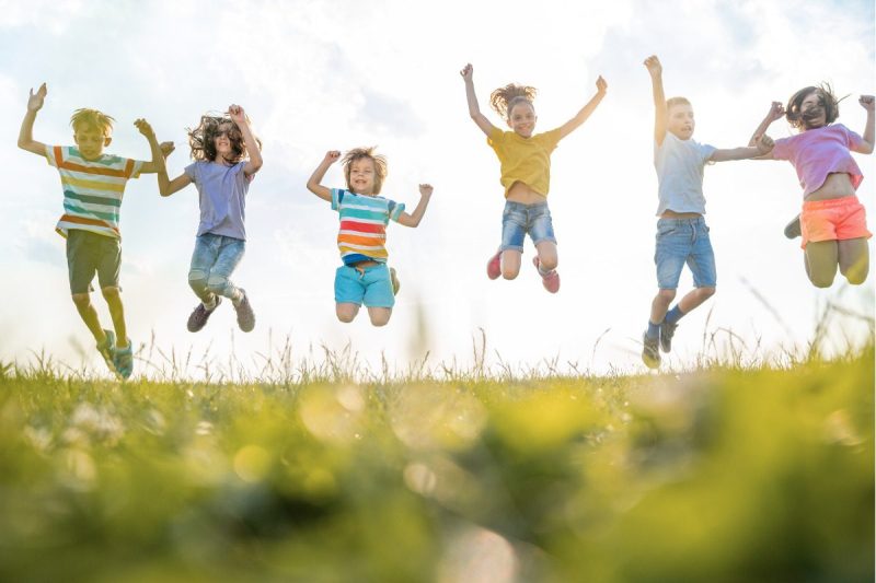 Kids jumping in nature. Earth day.