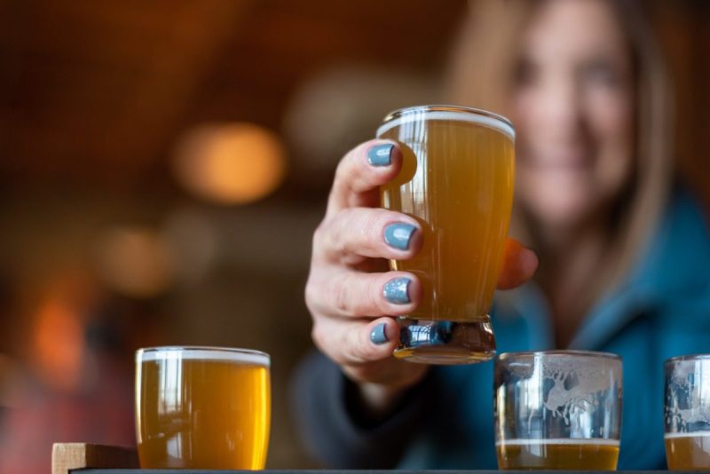 a closeup of a hand holding a glass of beer