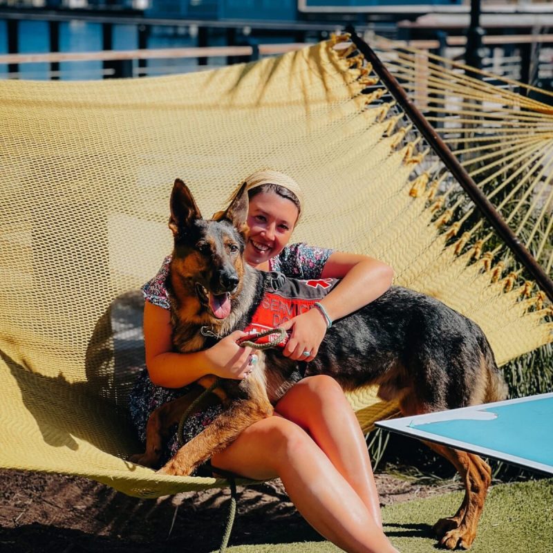 a chronically ill woman sitting outside holds her dog