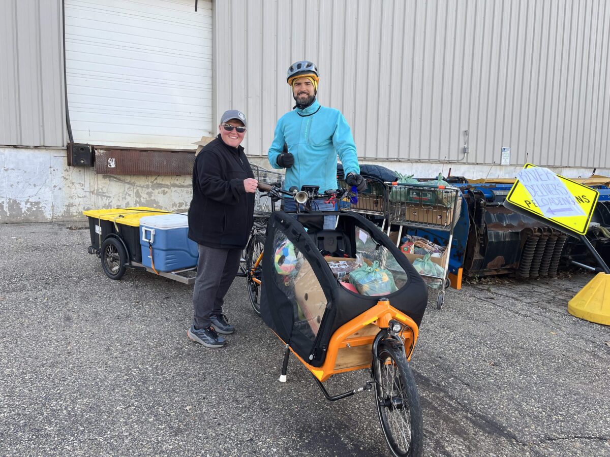 Jamie Midthun from The River Food Pantry and Pepe Barros with the fully loaded cargo bike for Bikes for Kids Wisconsin.