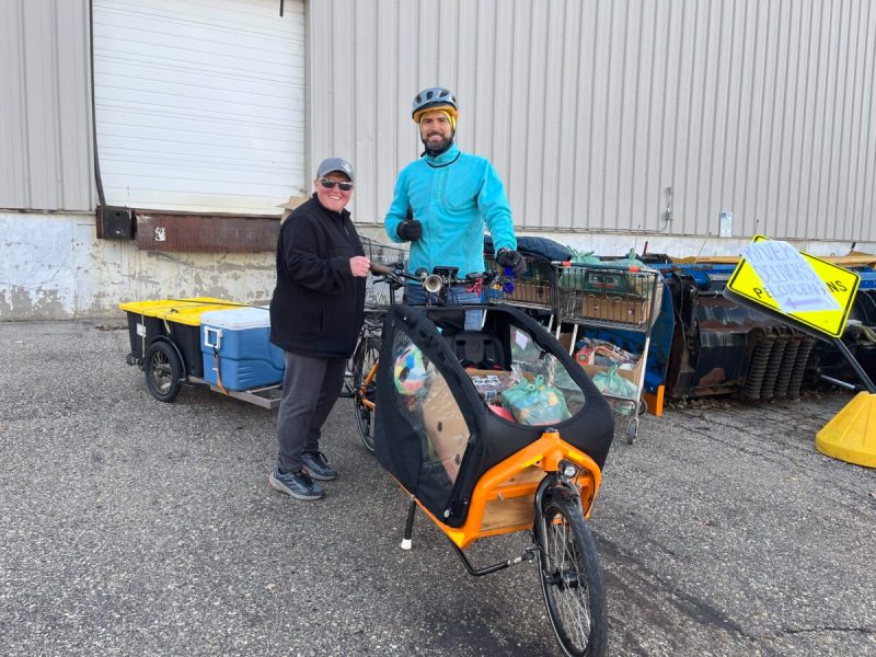 Jamie Midthun from The River Food Pantry and Pepe Barros with the fully loaded cargo bike for Bikes for Kids Wisconsin.