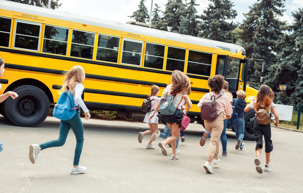 Children running to a school bus. 