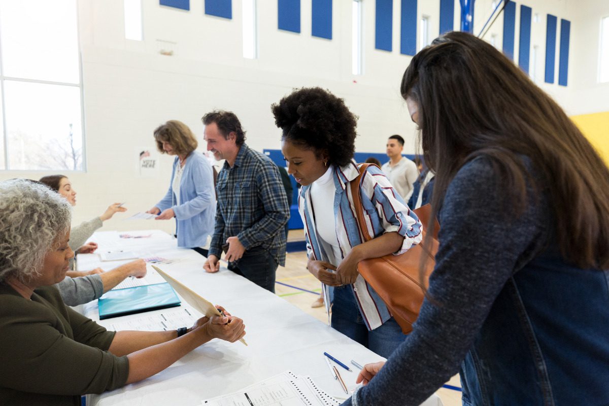 April 7 Wisconsin Spring Election Questions. Polling place volunteers assist voters with voting documents