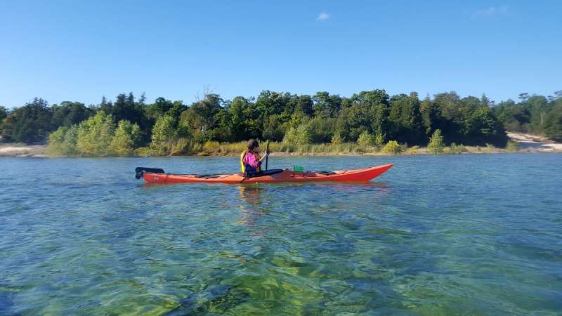 A kayaker paddles along the southern shore of Rock Island State Park