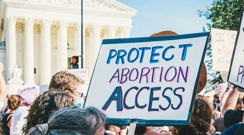 Protect abortion access sign at protest. Photo by Gayatri Malhotra on Unsplash