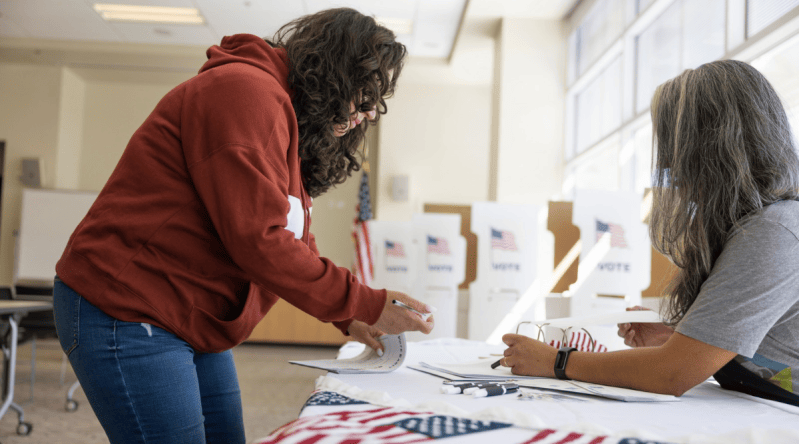 Poll worker and voter. LPETTET/ Getty Images Signature